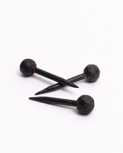 A group of three round head iron nails. Shown lying on their sides.