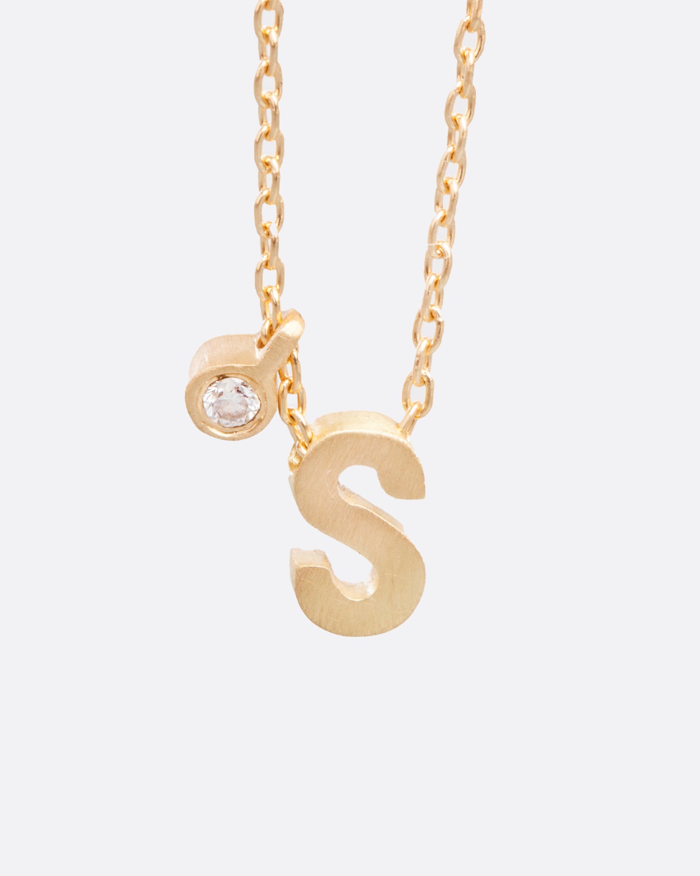 This micro initial necklace features a block letter of your choice hanging from a cable chain with an optional separate bezel set diamond tag.