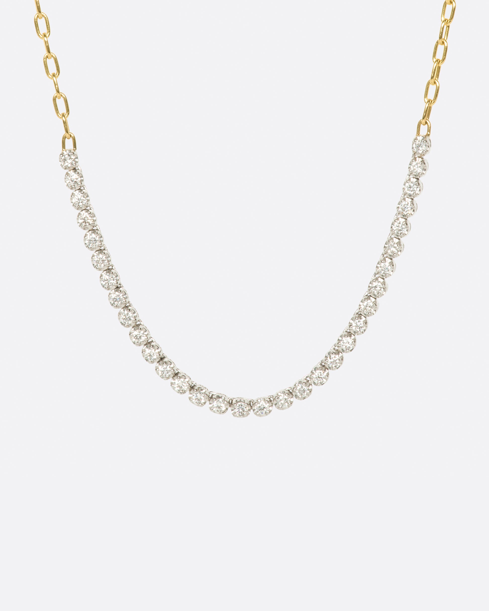 A yellow gold, oval link, chain necklace with four inches of contrasting white diamonds.