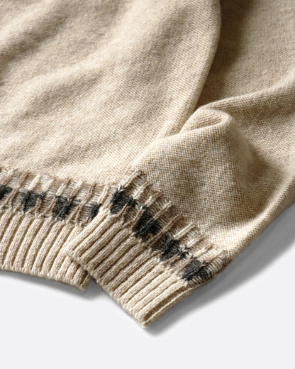 A close up on the sleeves of a Nordic patterned sweater. Shown lying flat.