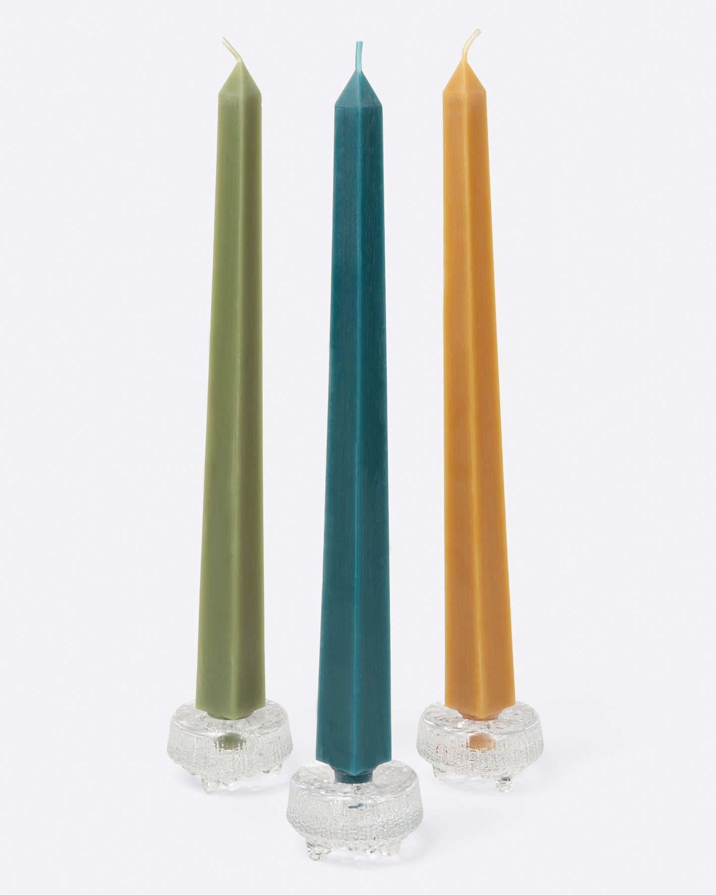 Three square taper candles in glass candle holders.