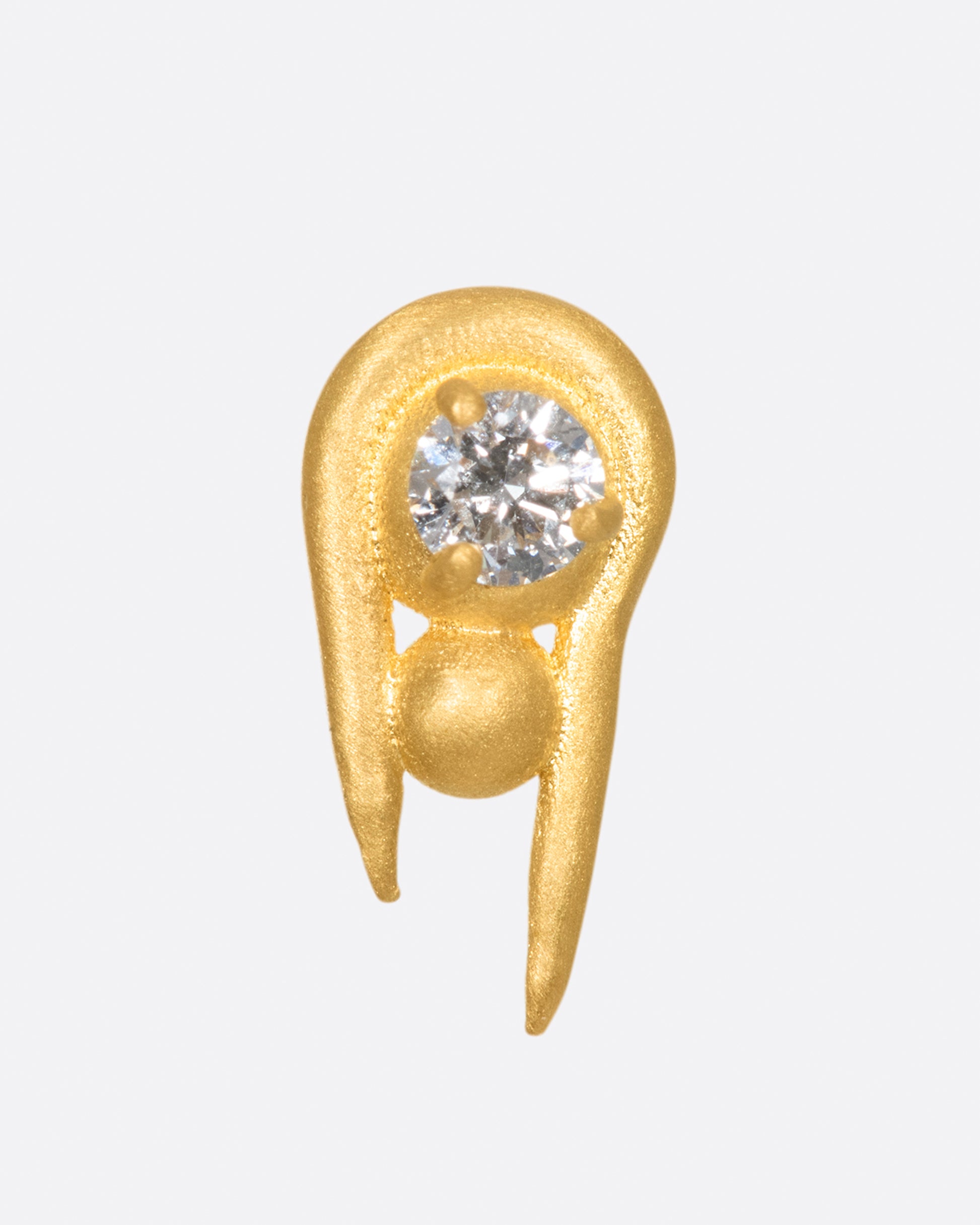 A curved high karat gold earring with a stacked sphere and brilliant cut diamond.