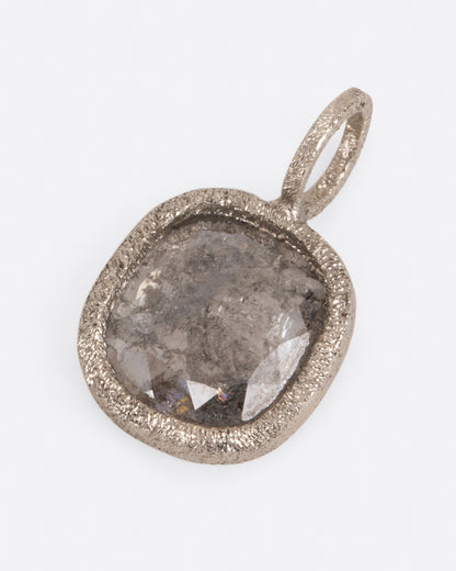 A pendant with a square salt and pepper diamond set in white gold. Shown lying flat from the front.