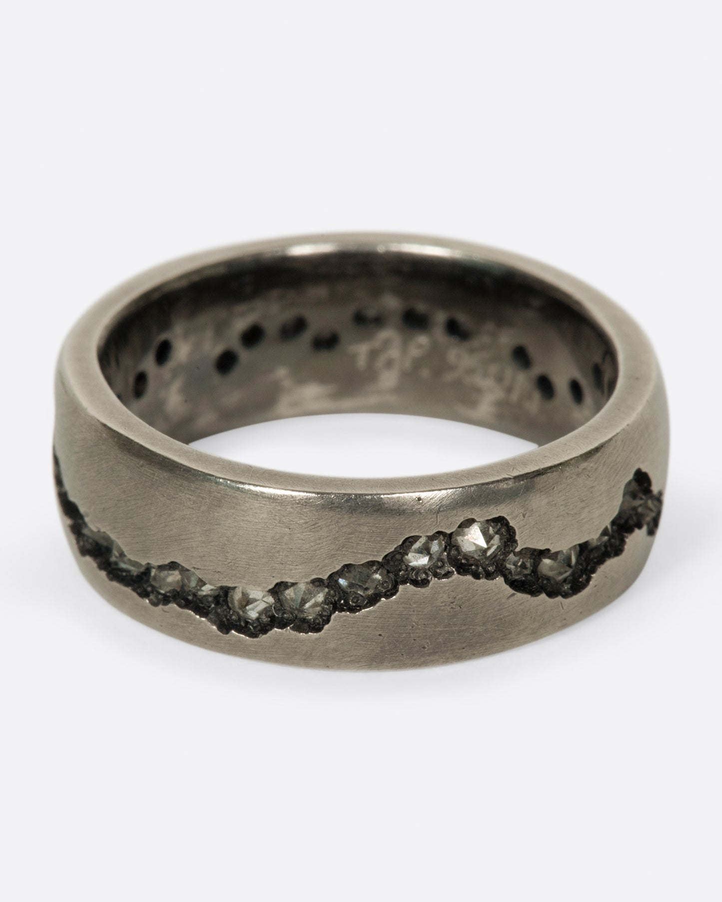 A wide palladium band with inverted diamonds set in a hand cut fissure through the center of the ring.