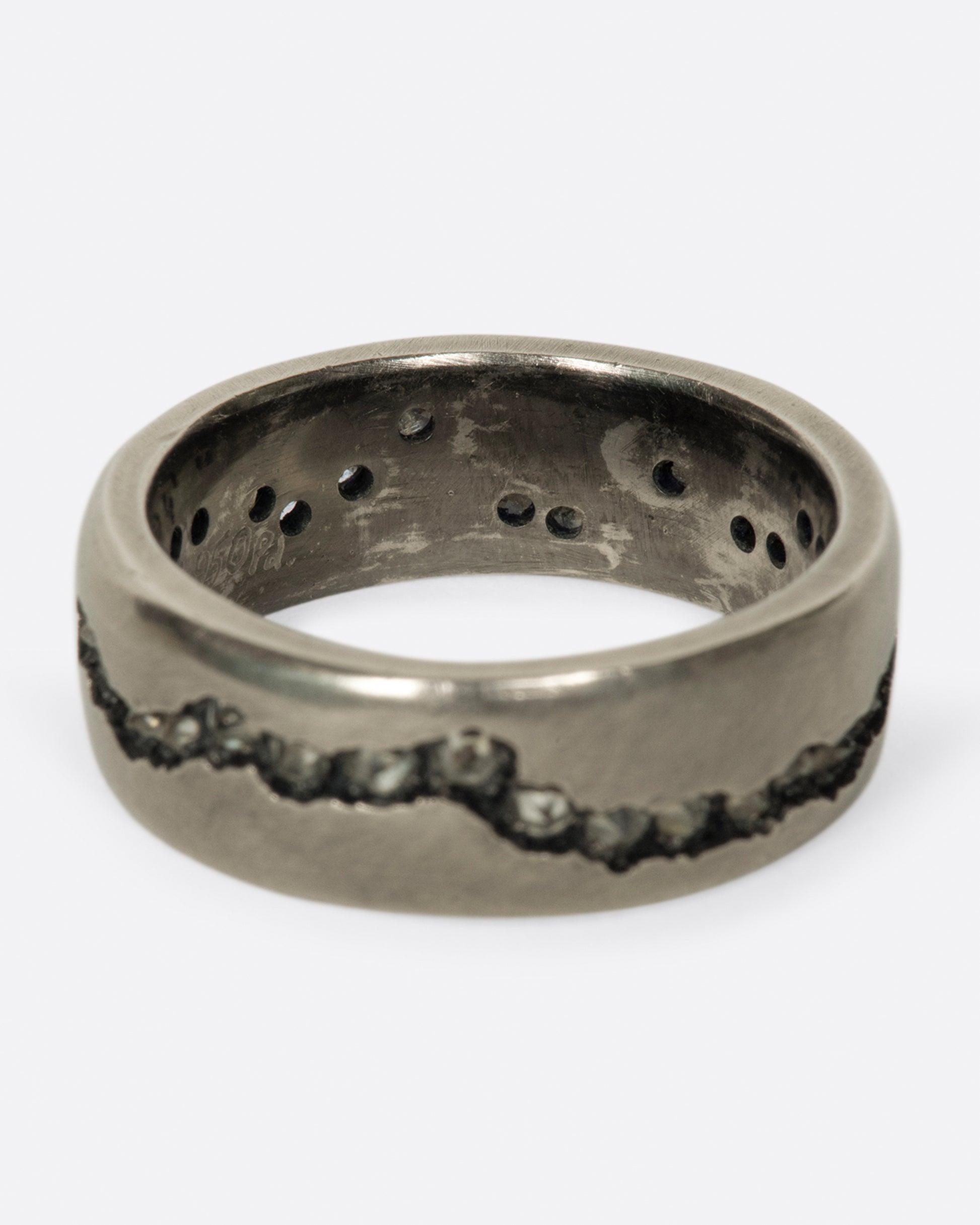 A wide palladium band with inverted diamonds set in a hand cut fissure through the center of the ring.