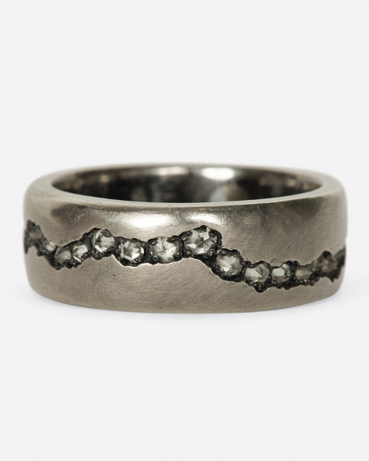 A wide palladium band with inverted diamonds set in a hand cut fissure through the center of the ring.