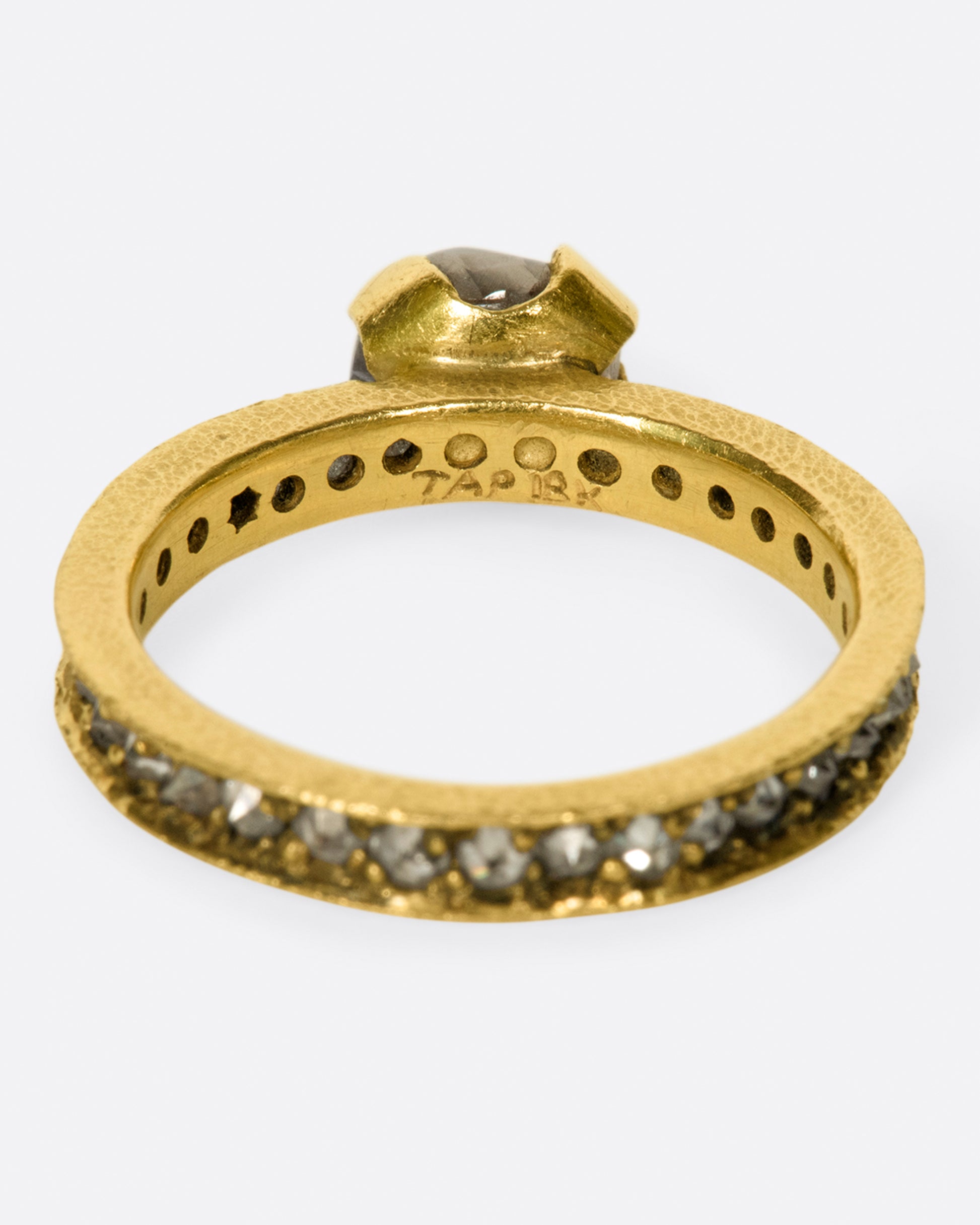 A yellow eternity band with inverted diamonds, crowned by a prong set raw yellow diamond.