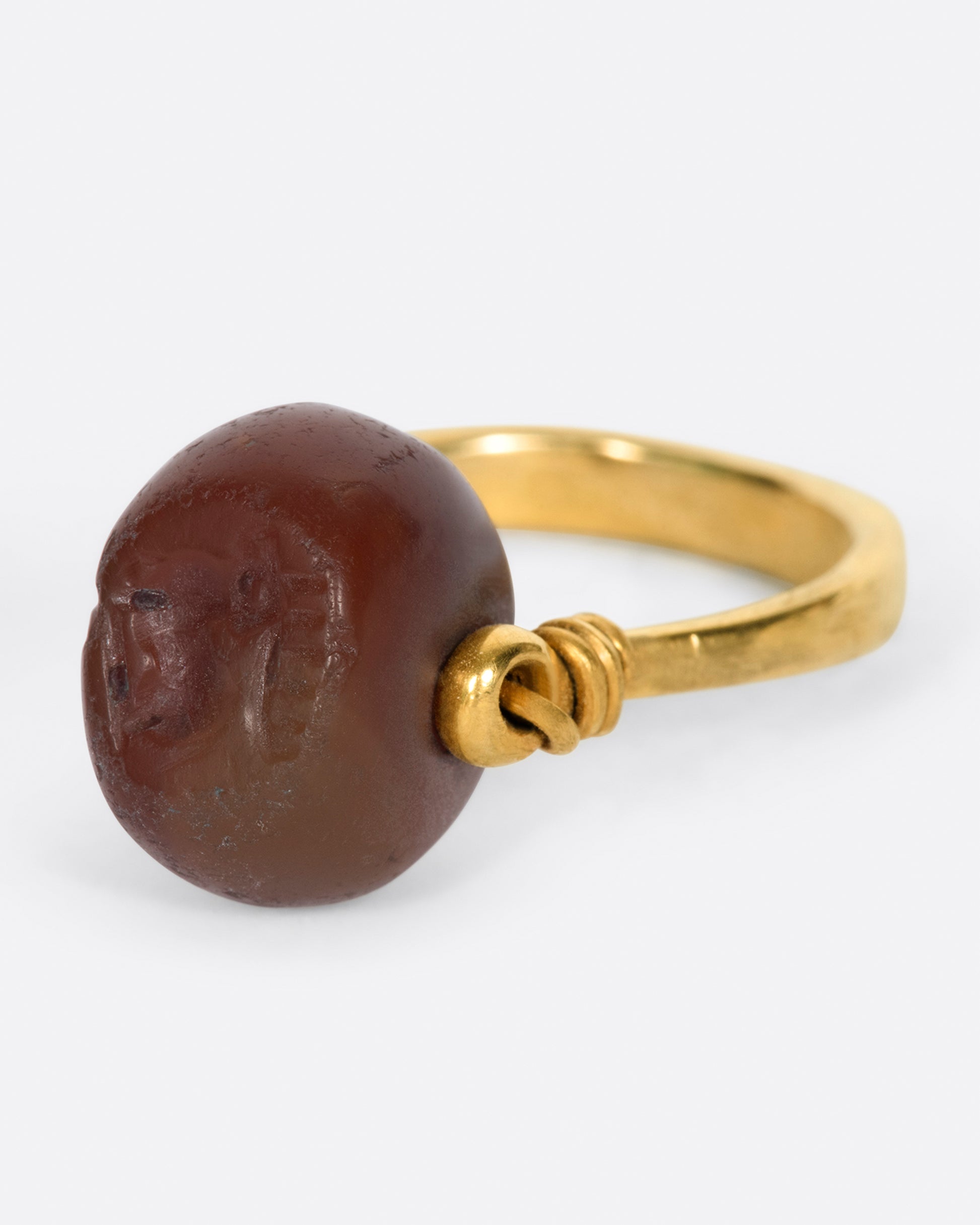 yellow gold ring with a carnelian stone that flips over and a stag carved into it