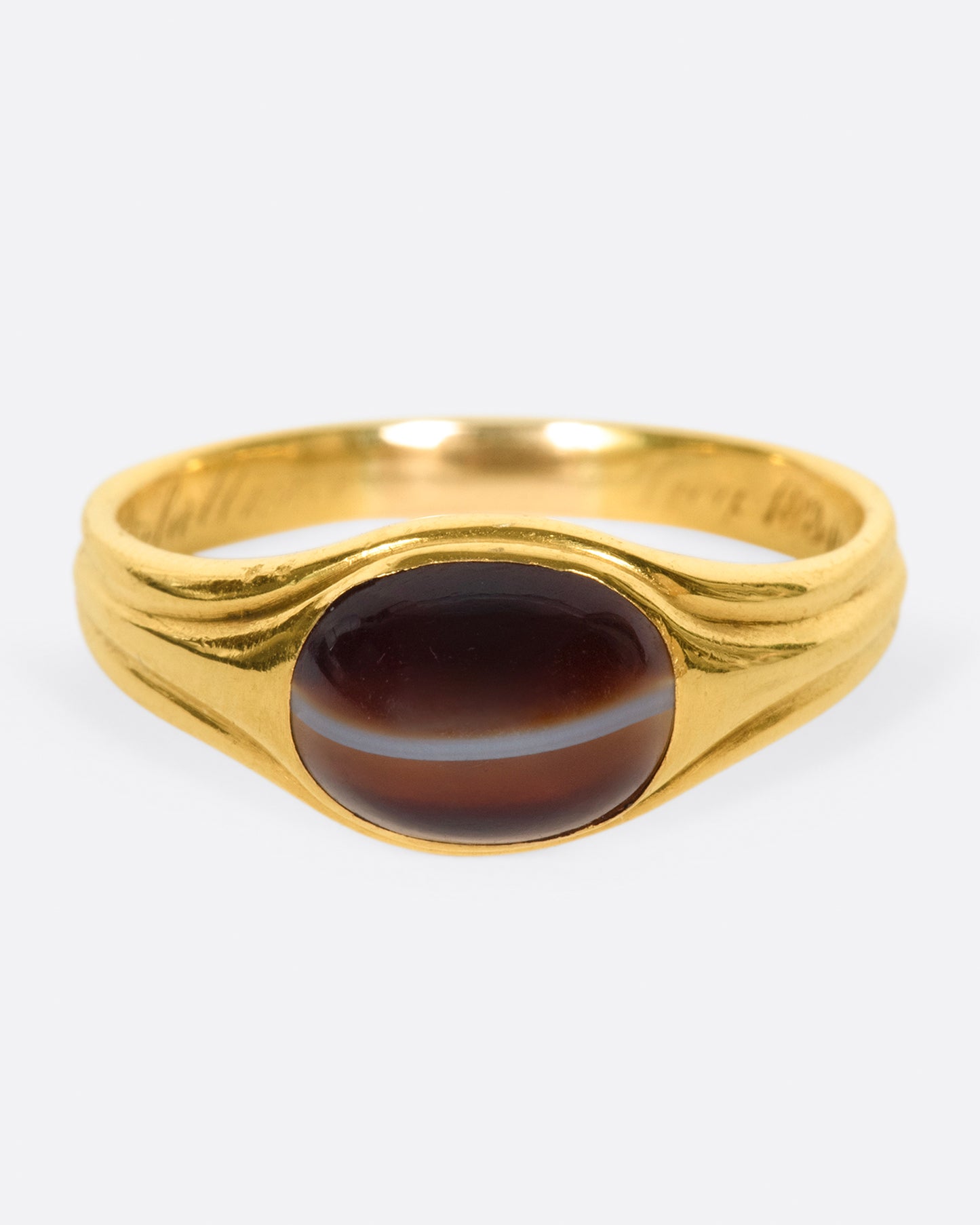 A vintage gold signet ring with a banded deep red oval agate at its center.