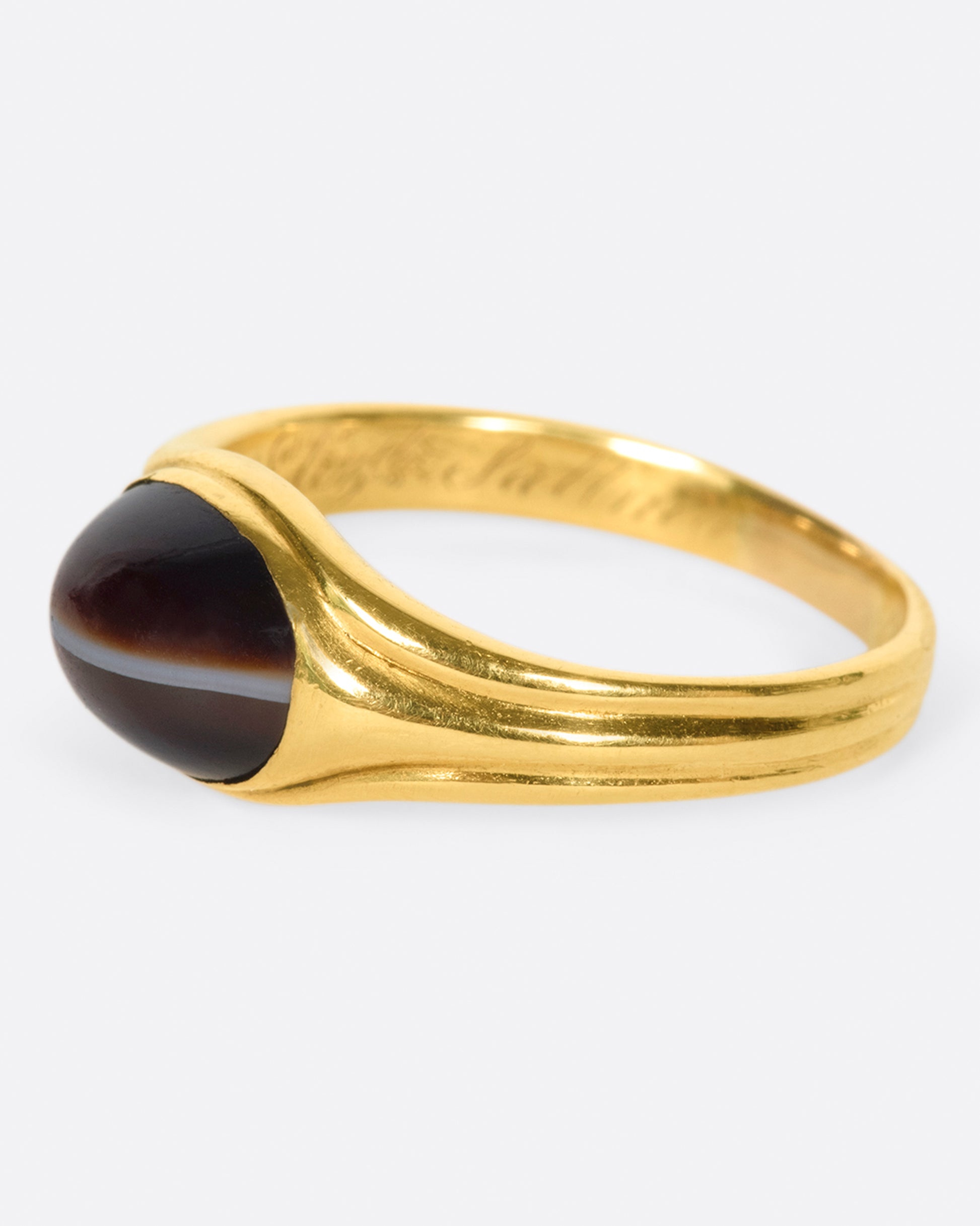 A vintage gold signet ring with a banded deep red oval agate at its center.