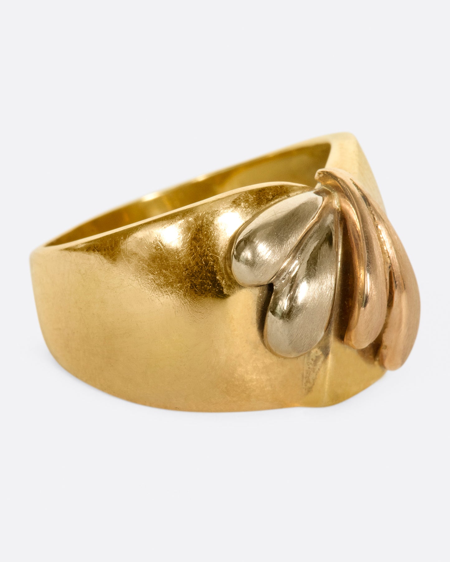 A wide, dimpled yellow gold band with white and rose gold teardrop accents.