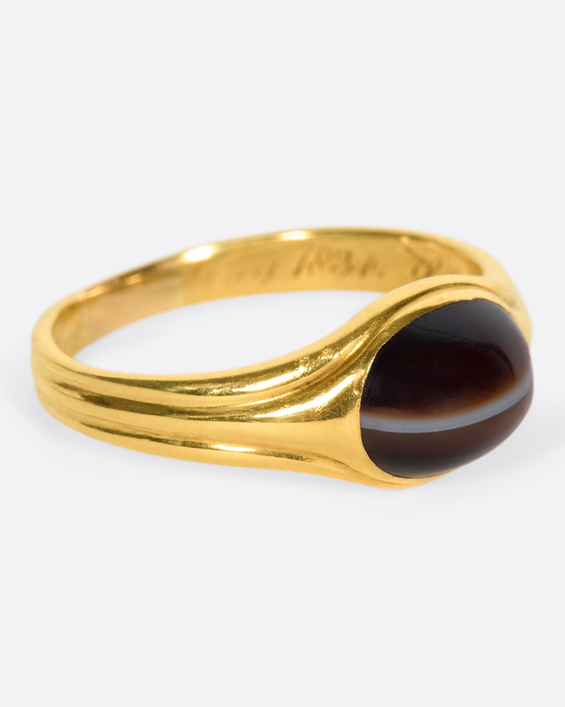 A vintage gold signet ring with a banded deep red oval agate at its center.