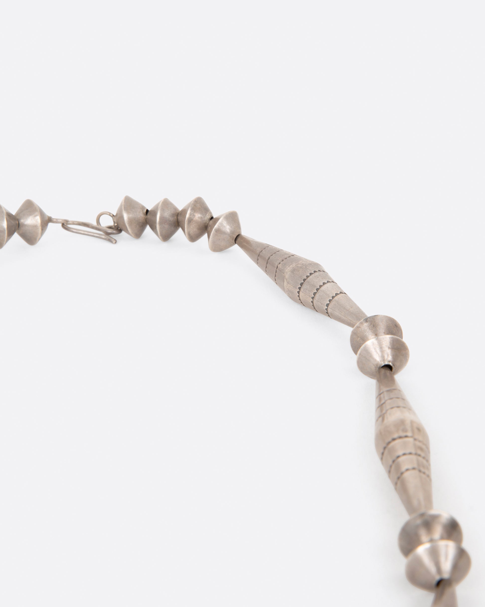 A close up of the beads on a vintage silver naja necklace.